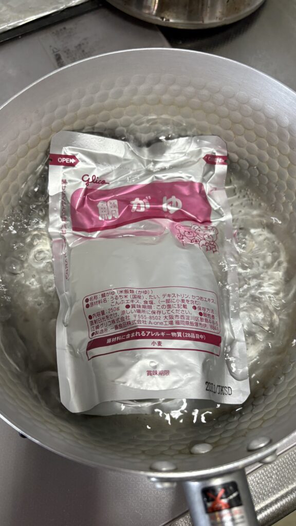 鯛がゆのパウチを湯せんしている様子